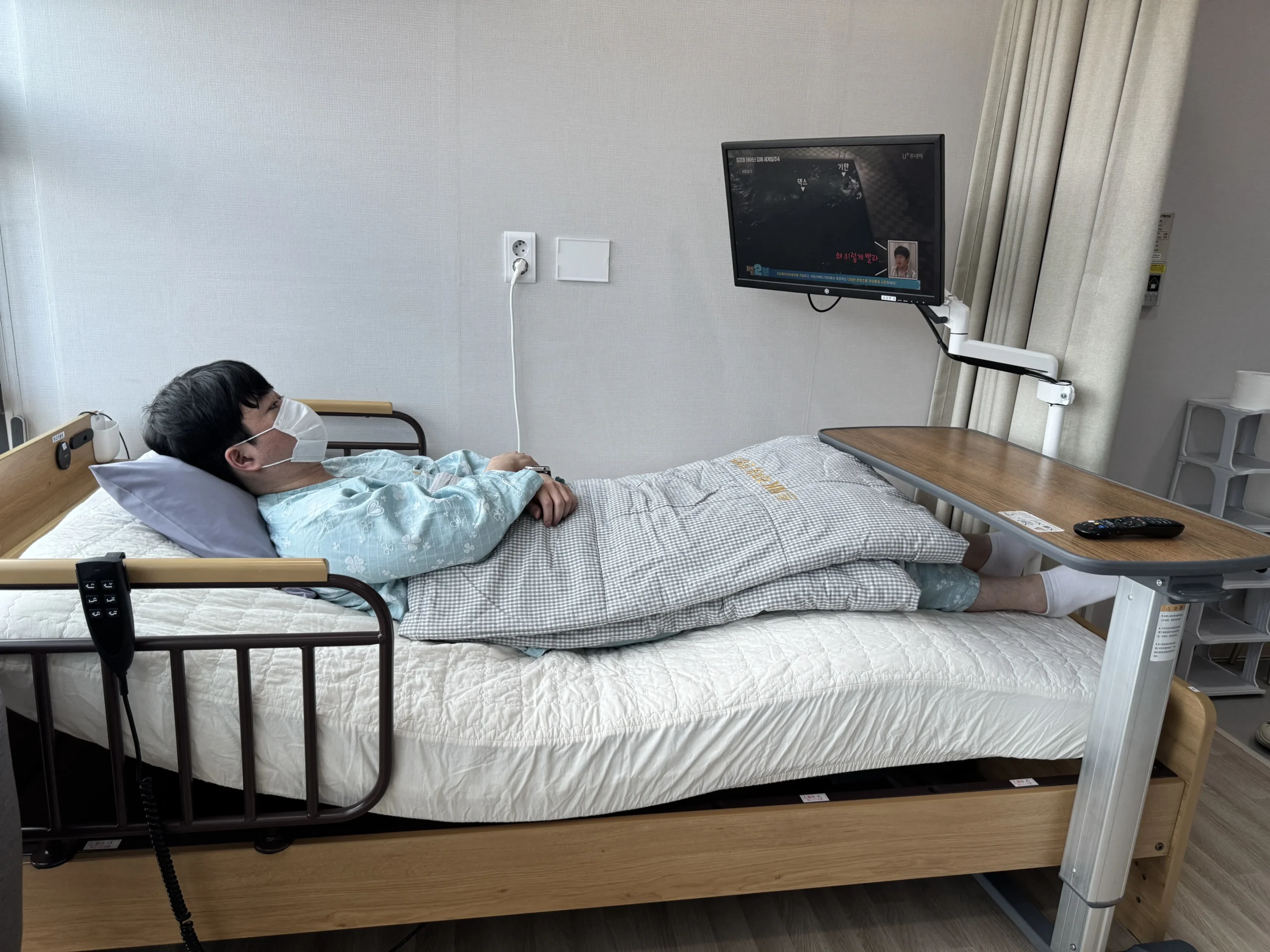 대구 암 환자 체력 회복|병실 침대에 누워 TV를 시청 중인 환자